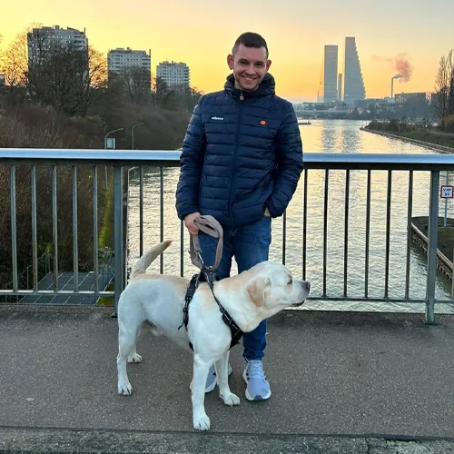 Marco mit seinem Labrador Luca auf einer Brücke